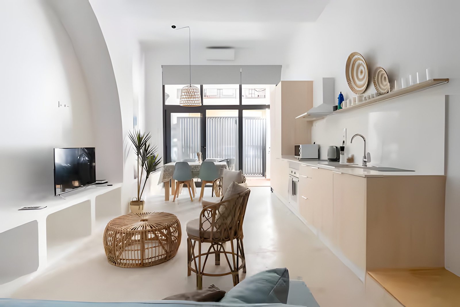 Zona de comedor junto a la ventana, con la cocina al fondo